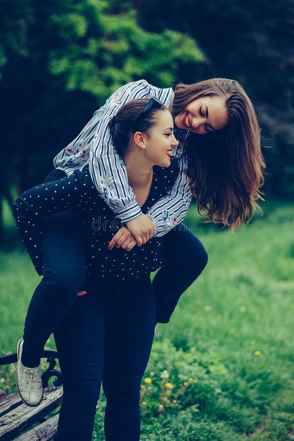 Outdoor Shot of Young Woman Carrying Her Female Friend on Her Back ...