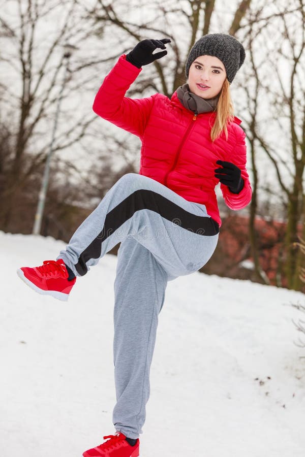 Woman Wearing Sportswear Exercising Outside during Winter Stock