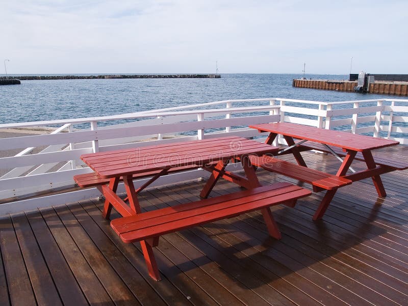 Outdoors Picnic tables by the sea royalty free stock photo