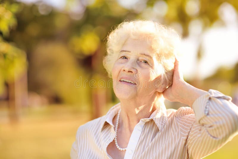 Outdoors portrait of beautiful smiling senior woman with curly white hair royalty free stock photography Outdoors portrait of beautiful smiling senior woman with curly white hair royalty free stock photography