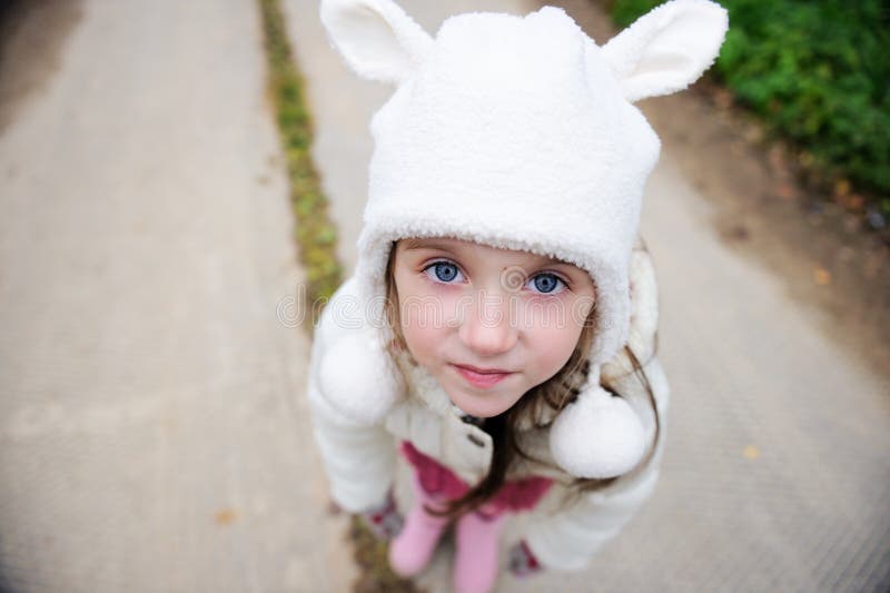 Outdoors portrait of a child girl in warm hat