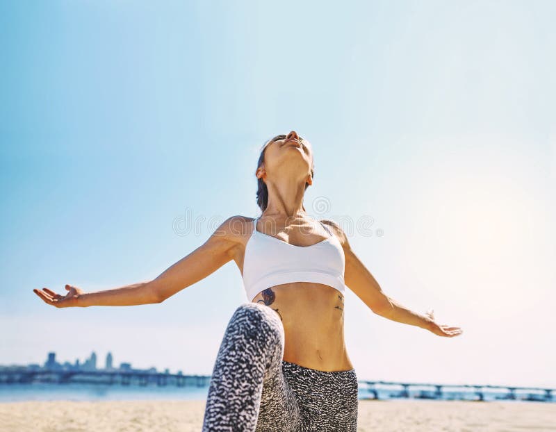 Outdoors portrait of young slim athletic woman standing in yoga asana with raised arms on the city and blue sky. Background. young pretty fitness lady mixed royalty free stock photos Outdoors portrait of young slim athletic woman standing in yoga asana with raised arms on the city and blue sky. Background. young pretty fitness lady mixed royalty free stock photos
