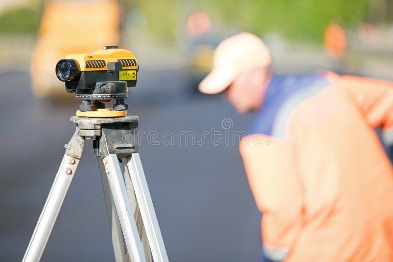 Outil de théodolite au chantier de construction pendant les courses sur route images stock Outil de théodolite au chantier de construction pendant les courses sur route images stock