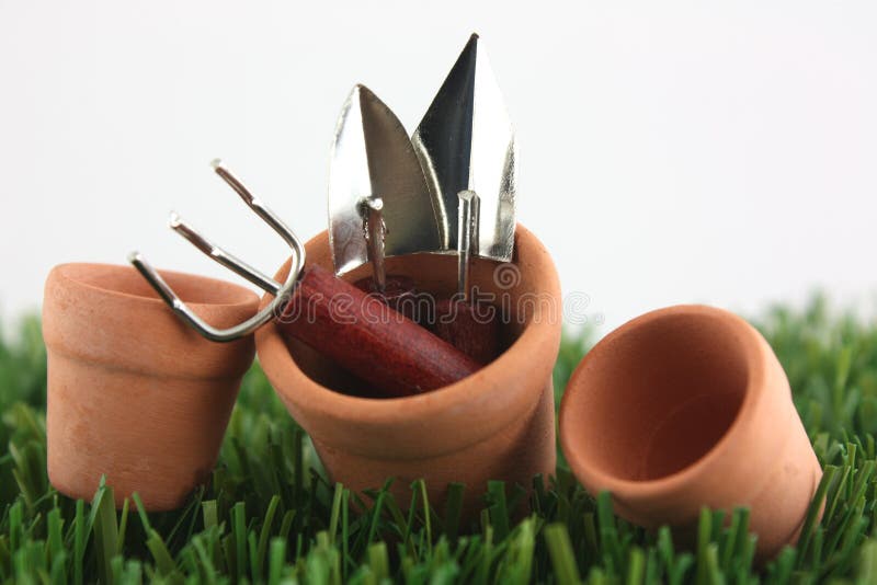 Gardening tools in pots on grass. Gardening tools in pots on grass