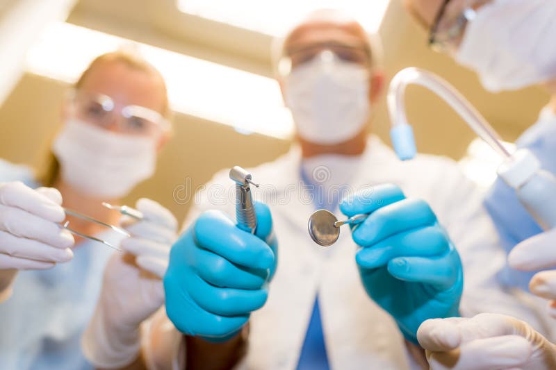 Dental tools in action bottom view of professional medical team. Dental tools in action bottom view of professional medical team