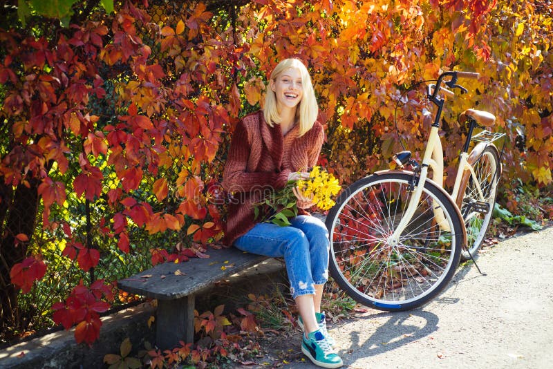 Outono morno Menina com bicicleta e flores Jardim do outono da bicicleta da mulher Lazer e estilo de vida ativos outono simples fotografia de stock Outono morno Menina com bicicleta e flores Jardim do outono da bicicleta da mulher Lazer e estilo de vida ativos outono simples fotografia de stock
