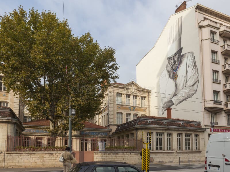 Outside Les Halles in Lyon a picture of Paul Bocuse adorns the wall of a building. Paul Bocuse was a French chef based in Lyon who was known for the high quality of his innovative approaches to cuisine. Les Halles Paul Bocuse is a covered food market that concentrates some of Lyonâ€™s best known local delicacies. Outside Les Halles in Lyon a picture of Paul Bocuse adorns the wall of a building. Paul Bocuse was a French chef based in Lyon who was known for the high quality of his innovative approaches to cuisine. Les Halles Paul Bocuse is a covered food market that concentrates some of Lyonâ€™s best known local delicacies.