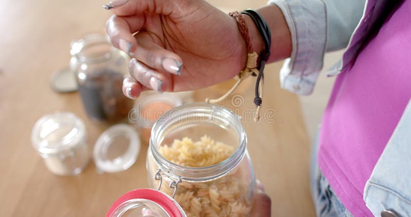 Ouverture du pot de pâtes femme préparant les ingrédients dans la cuisine avec le sourire banque de vidéos