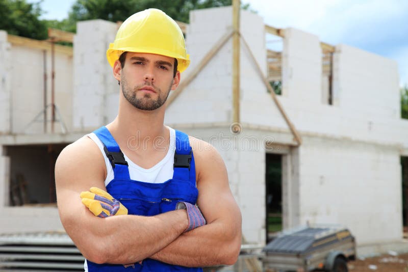 Ouvrier manuel devant le chantier de construction