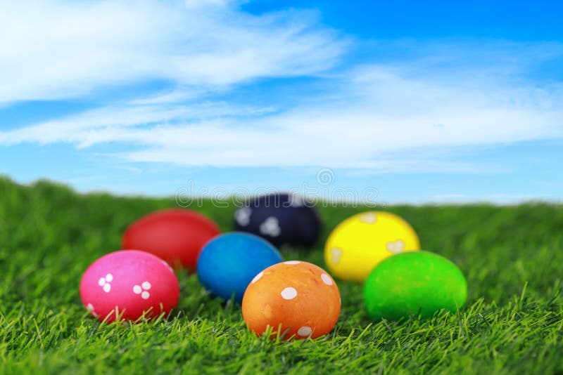 Ouă colorate și decorate de paști minunați pe iarbă verde în natură cu fond albastru. publicație pentru imagini royalty free stock image