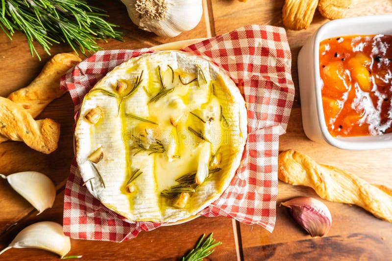 Oven Baked Camembert med vitlök, rosmarin och chutney royaltyfri bild Oven Baked Camembert med vitlök, rosmarin och chutney royaltyfri bild