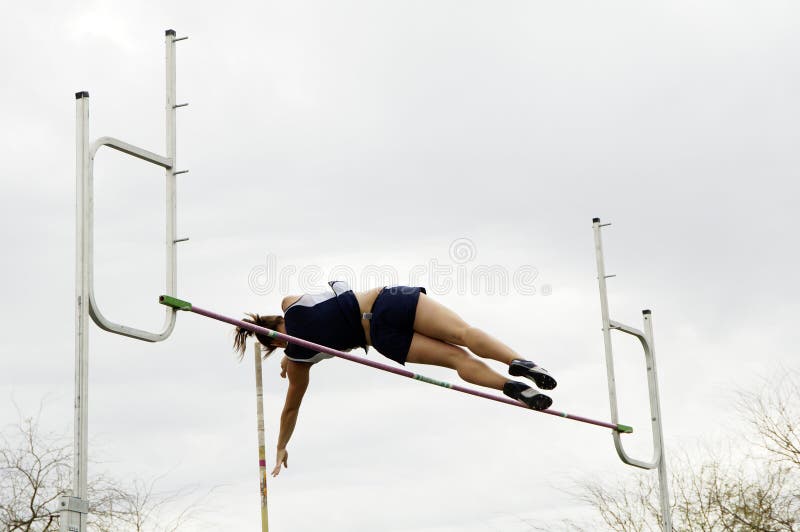 A competitor clears the bar in the women's pole vault event during a college track meet. A competitor clears the bar in the women's pole vault event during a college track meet.