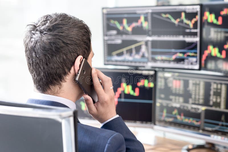 Over the shoulder view of computer screens and stock broker trading online. royalty free stock photos