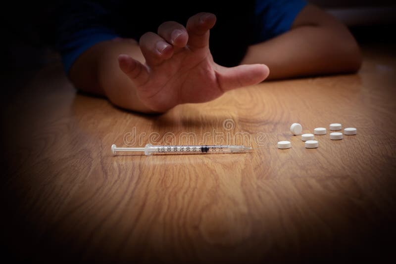 Overdose a mão masculina do viciado em drogas, seringa narcótica das drogas