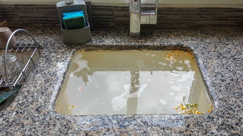 Overflowing kitchen sink, clogged drain.