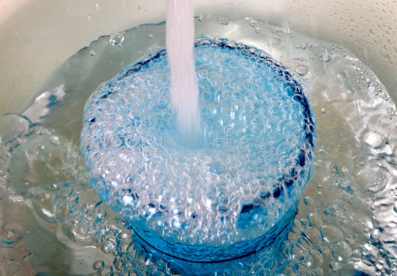 Overflowing water in a blue glass