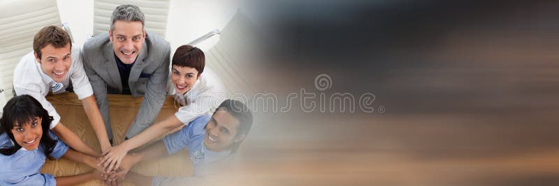 Overhead of business team looking up and putting hands together at table and blurry sunset transitio stock image Overhead of business team looking up and putting hands together at table and blurry sunset transitio stock image