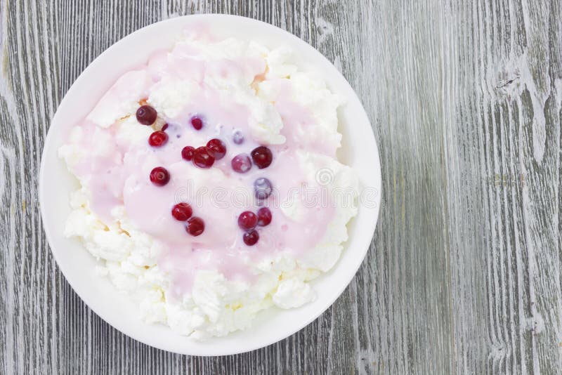 An overhead photo of fresh natural cottage cheese with cranberry yogurt in a white ceramic bowl on the wooden table. Organic eco royalty free stock images An overhead photo of fresh natural cottage cheese with cranberry yogurt in a white ceramic bowl on the wooden table. Organic eco royalty free stock images