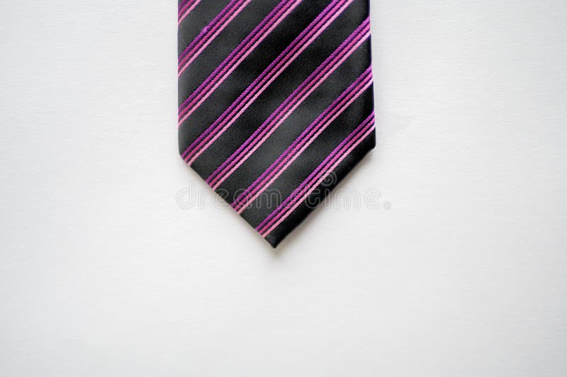 Overhead Shot of a Black Tie with Purple Stripes on a White Surface