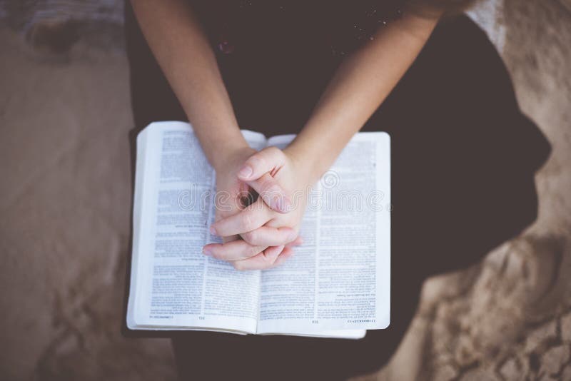 Overhead shot of a female praying with her hands on the bible royalty free stock images Overhead shot of a female praying with her hands on the bible royalty free stock images