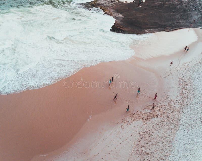 Overhead shot of people enjoying a sunny day at a sandy beach near beautiful waves of the sea royalty free stock images Overhead shot of people enjoying a sunny day at a sandy beach near beautiful waves of the sea royalty free stock images