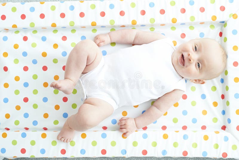 Overhead View Of Baby Girl Lying On Colorful Change Mat royalty free stock photography Overhead View Of Baby Girl Lying On Colorful Change Mat royalty free stock photography