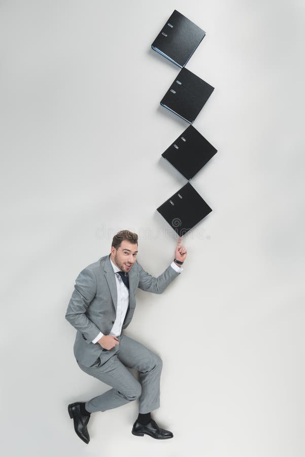 Overhead view of businessman holding stack of folders on one finger royalty free stock photography