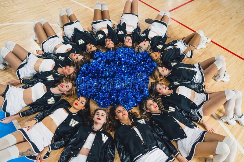 Premium Photo  Cheerleader girls team standing in lines with pompons in  front of them on a court