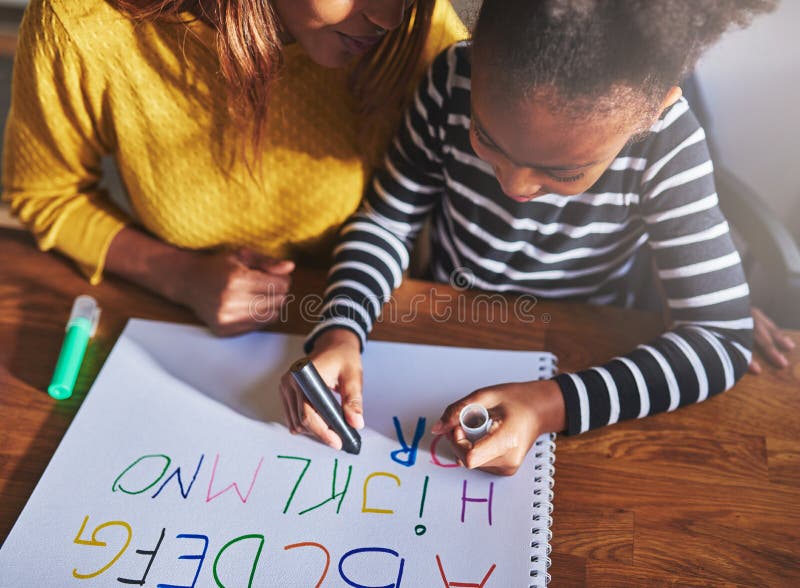 Overhead view of child learning alphabet