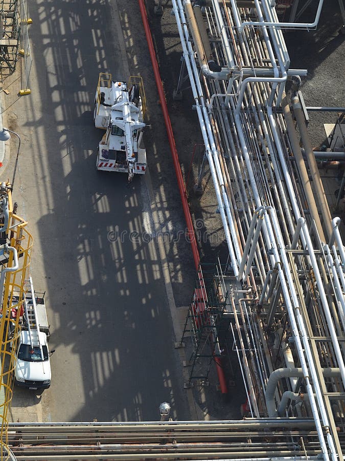 Overhead View of a Construction Worker Amongst Pipes and Scaffolding