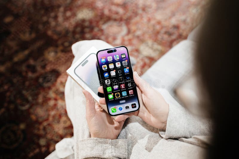 Overhead View Frau Hand halten neue tiefe violette neu freigelassene iphone 14 pro lizenzfreies stockfoto