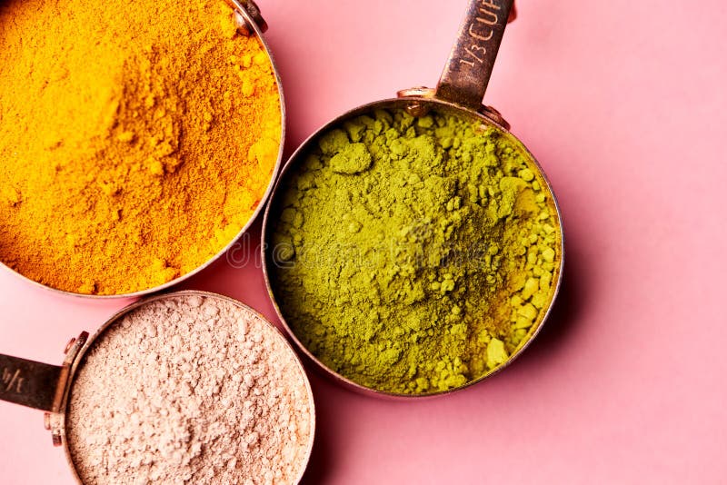 Overhead View Of Natural Beauty And Health Products In Measuring Cups On Pink Background