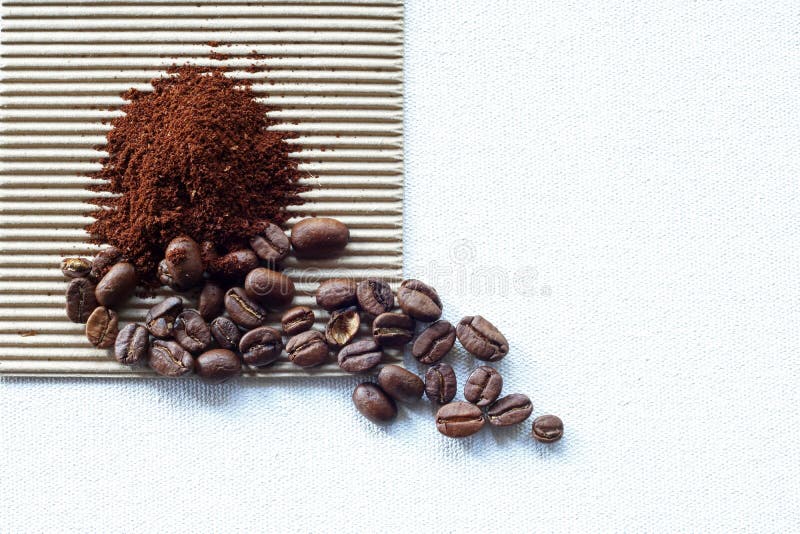 ROASTED COFFEE BEANS in a WHITE CERAMIC BOWL with GROUNDS on CORRUGATED