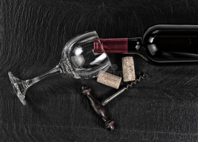 Overhead view of vintage corkscrew with red wine bottle and glass on black slate background stock photos Overhead view of vintage corkscrew with red wine bottle and glass on black slate background stock photos