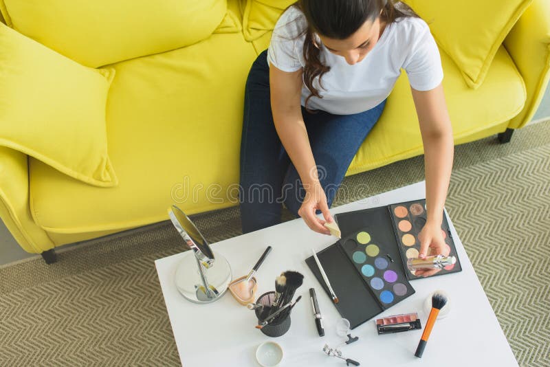 Overhead View Of Woman Sitting On Sofa At Coffee Table
