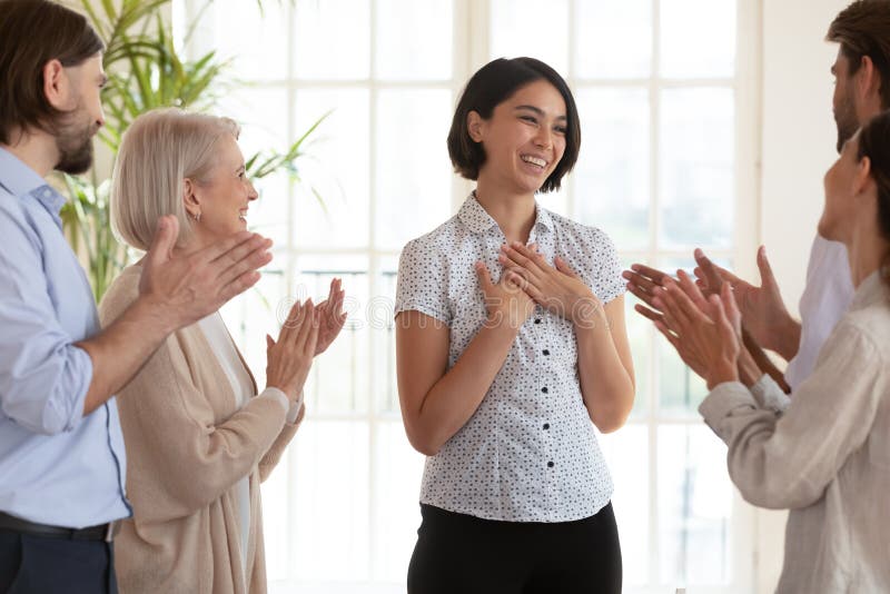 Overjoyed colleagues applaud Korean team leader greeting with success royalty free stock photo Overjoyed colleagues applaud Korean team leader greeting with success royalty free stock photo
