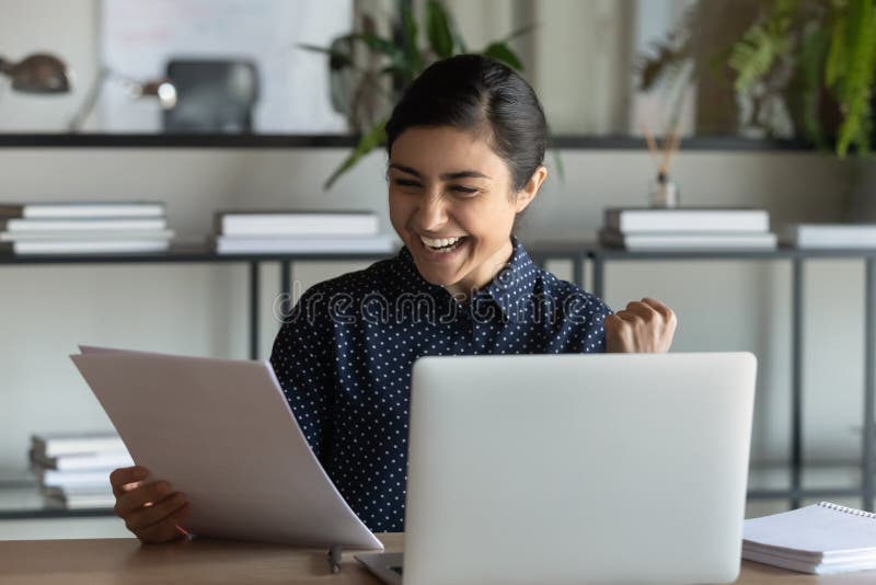 Overjoyed Indian female employee triumph with letter news