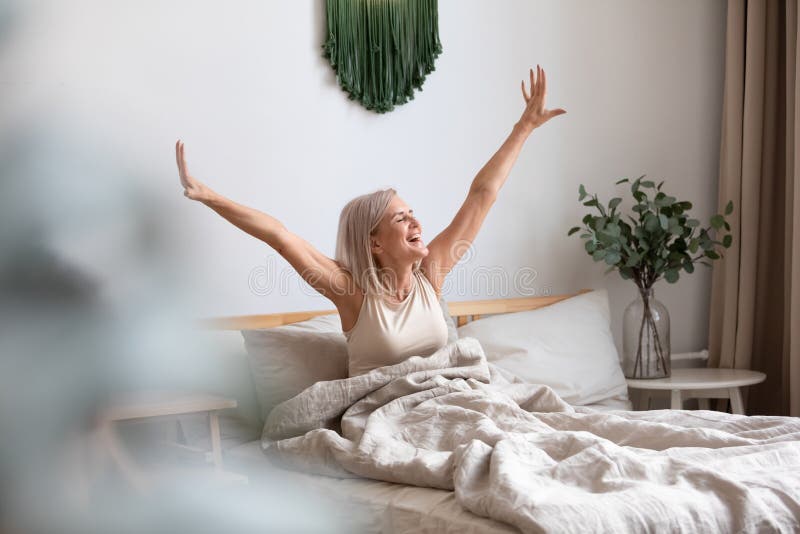 Overjoyed pleasant middle aged woman stretching muscles.