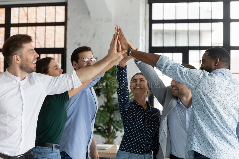 Overjoyed Successful Diverse Employees Giving High Five At Meeting