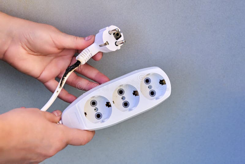 Extension cord overload, charred electrical cord with tee. Damaged extension cord stock images, royalty-free photos and pictures