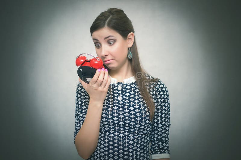 Overslept chocó a la mujer con el despertador rojo en fondo gris oversleep rezagado imágenes de archivo libres de regalías Overslept chocó a la mujer con el despertador rojo en fondo gris oversleep rezagado imágenes de archivo libres de regalías