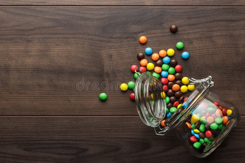 Overturned glass jar full of colorful sweets