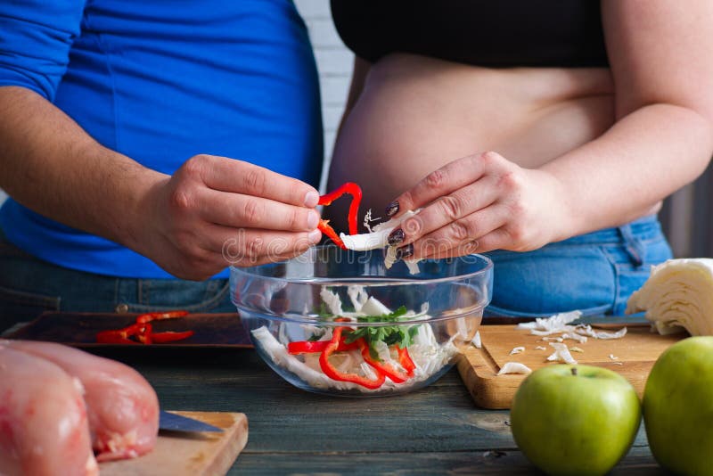 Overweight couple cooking vegetable salad. Dieting, weight losin stock image Overweight couple cooking vegetable salad. Dieting, weight losin stock image