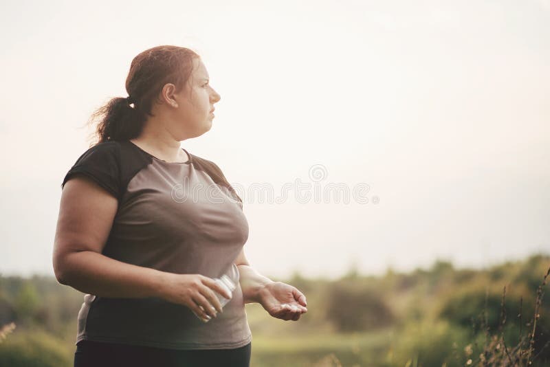 Overweight fat woman with a bottle of diet pills royalty free stock image Overweight fat woman with a bottle of diet pills royalty free stock image