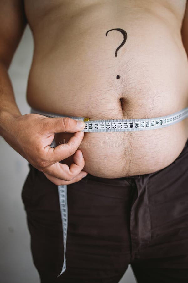 Overweight man measuring waist with measure tape, close up image. Weight  loss, motivation, fat burning Stock Photo