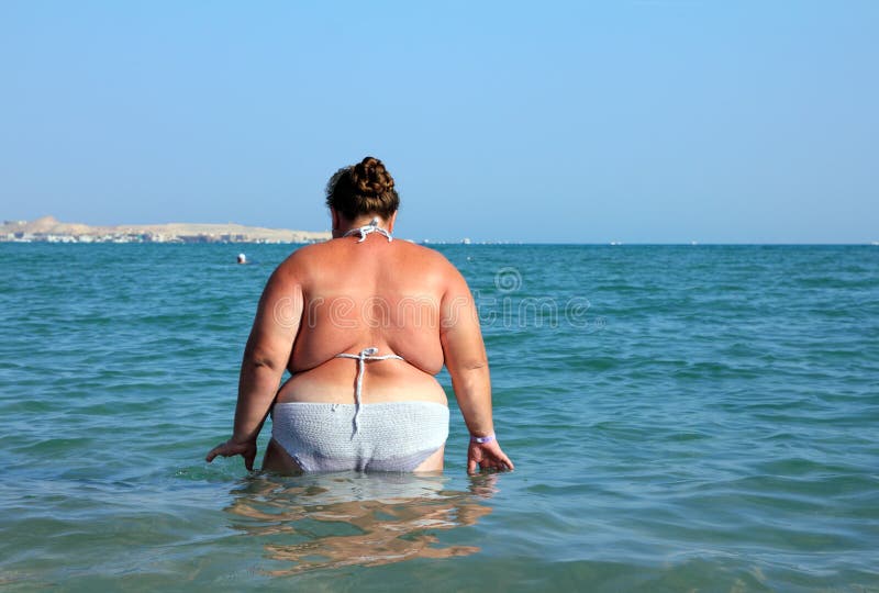 Overweight woman bath in sea royalty free stock photography