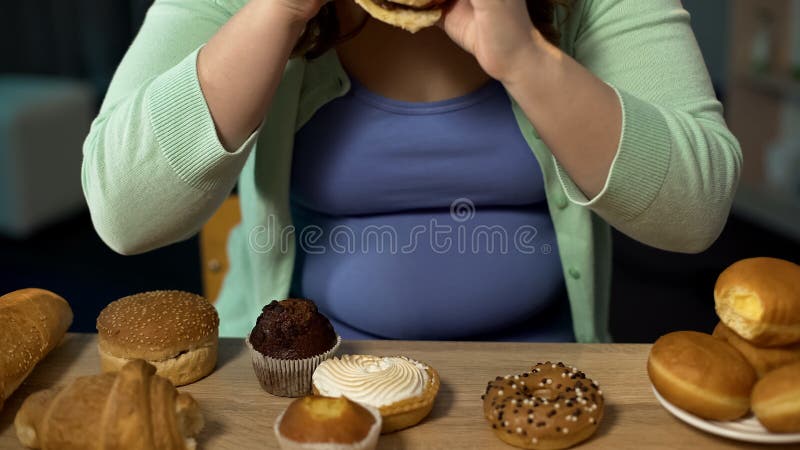 Overweight woman consuming too much bakery, eating stress with unhealthy sweets royalty free stock photography Overweight woman consuming too much bakery, eating stress with unhealthy sweets royalty free stock photography