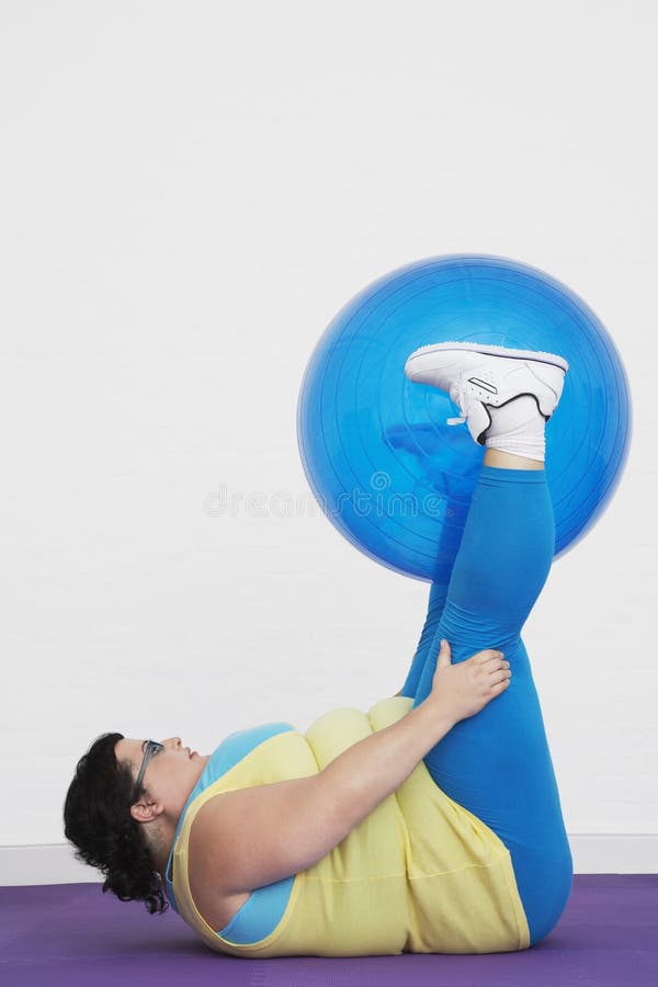 Overweight Woman Holding Up Exercise Ball with Legs Stock Image Image