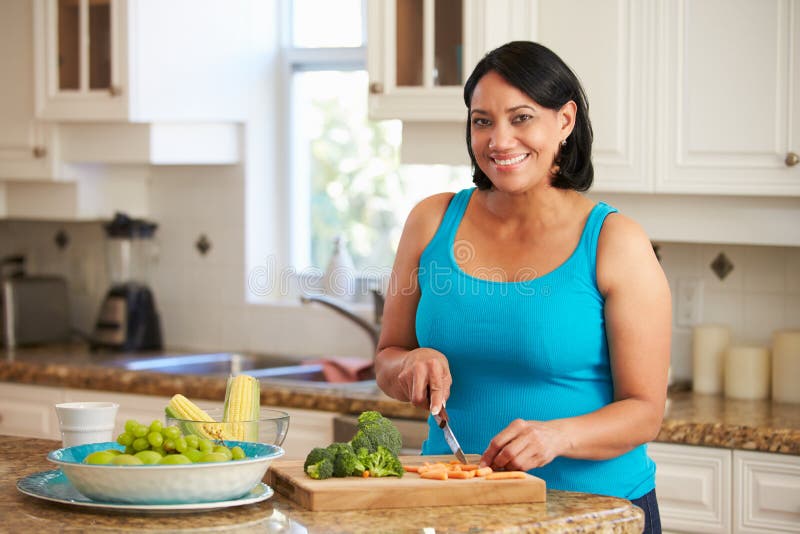 Overweight Woman Preparing Vegetables In Kitchen stock photos Overweight Woman Preparing Vegetables In Kitchen stock photos