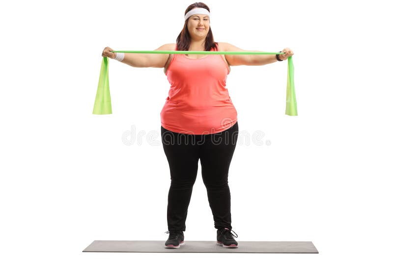 Overweight Woman Standing On A Mat And Exercising With A Rubber Stock